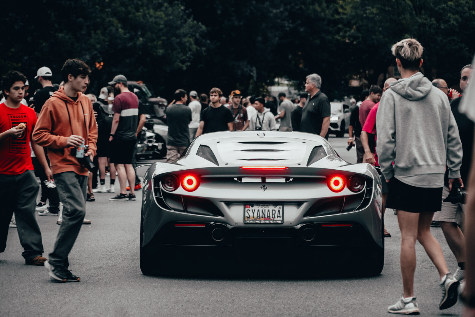 A silver Ferrari, rear detail, at a DMV car meet.