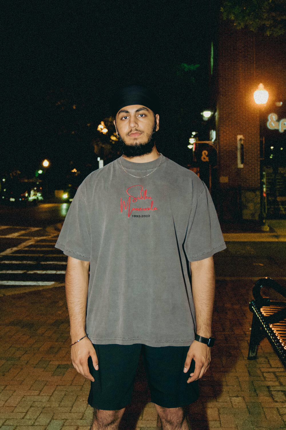 Portrait of MSflicks, photographer, standing on a downtown street corner at night.