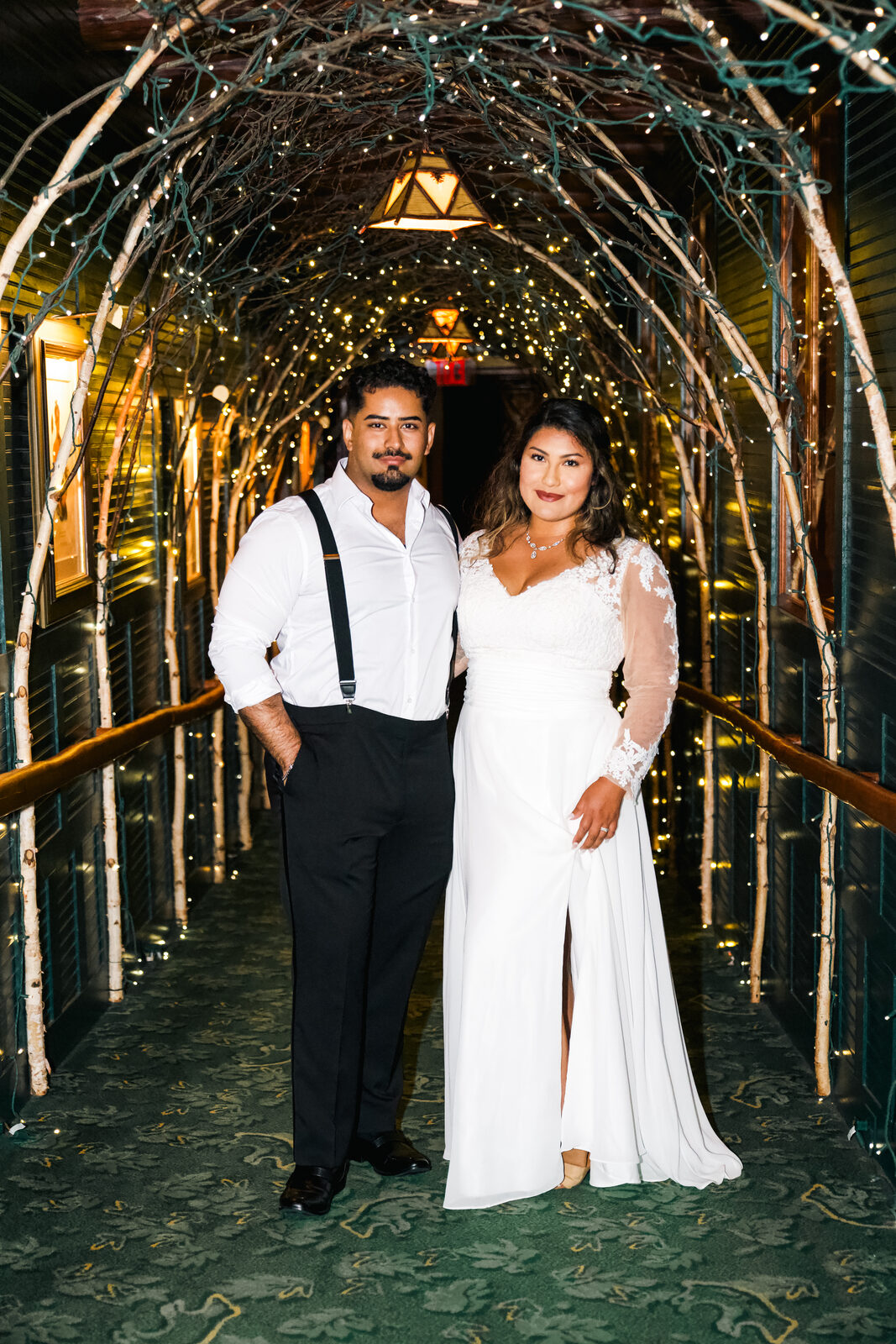 A couple walking through a lit archway walkway at the reception.