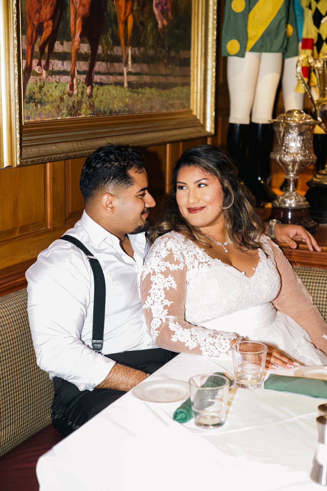 A candid moment of the couple laughing, raising a glass at the reception.