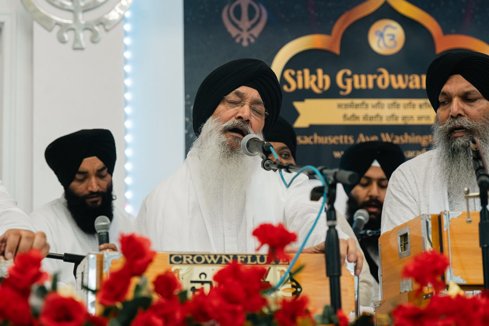 An elder singer performing at the microphone.