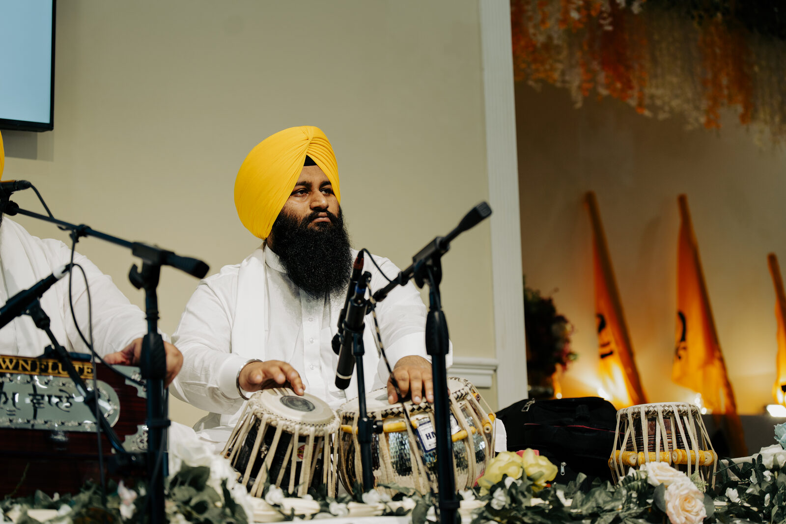 A tabla player performing, portrait framing.