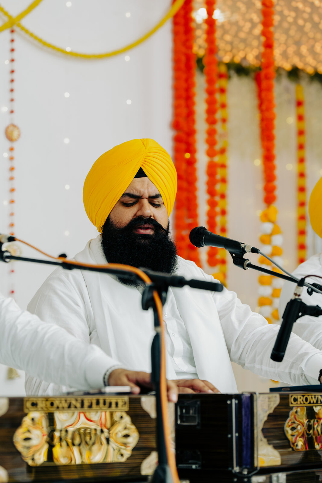 A close shot of a musician playing harmonium and tabla together.