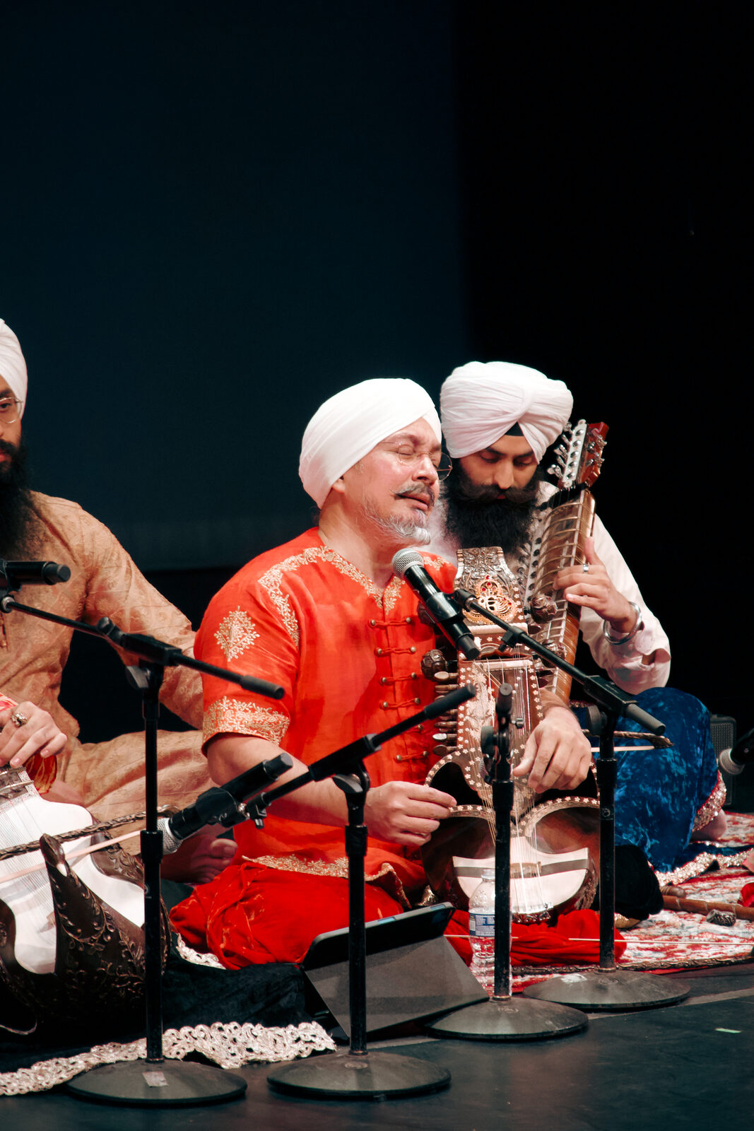 Two musicians playing sarangi and sarod together on stage.