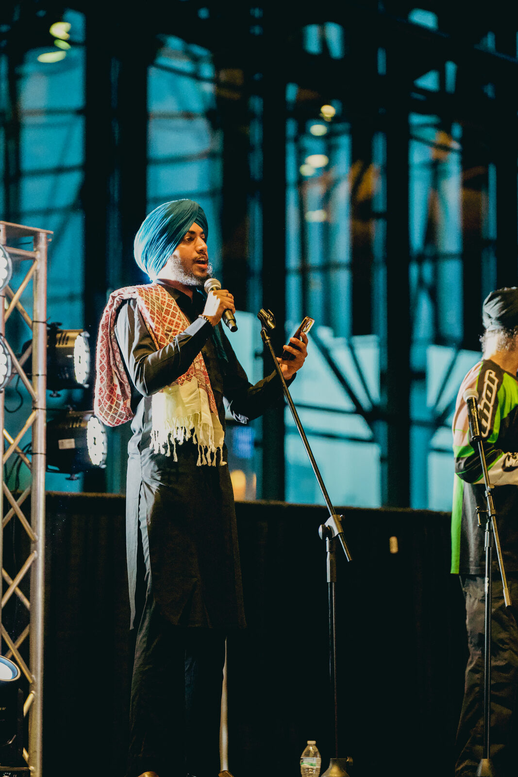 A performer singing into a microphone on stage.