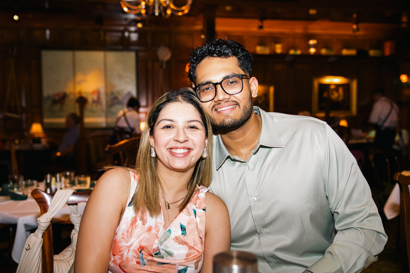 A celebratory portrait of the couple at a restaurant after the proposal.
